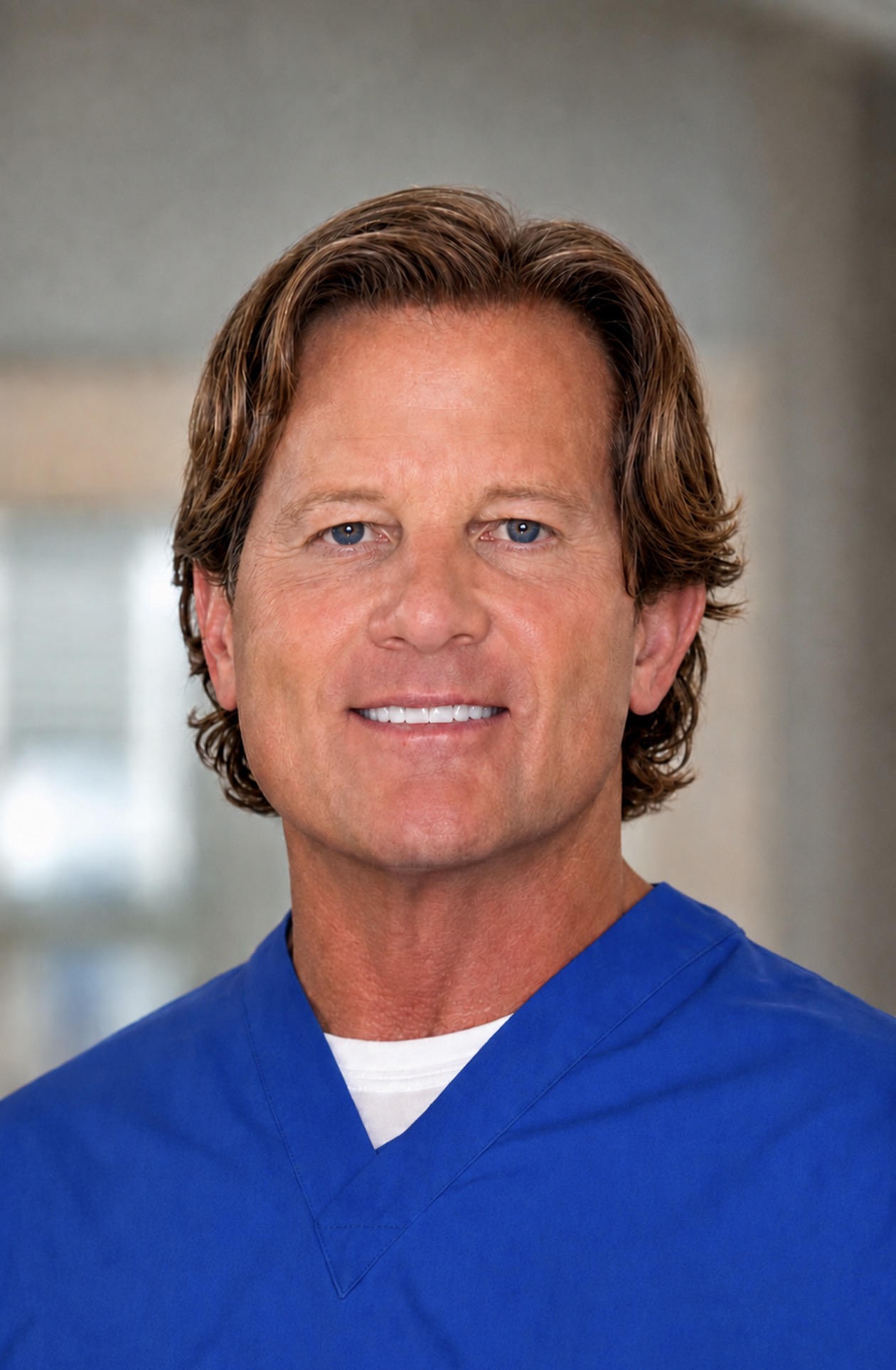 Dr. Peter E. Caldwell, wearing blue medical scrubs